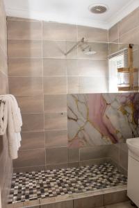 阿尔伯顿Neapolitan Guesthouse的一间带淋浴的浴室和瓷砖墙