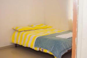 恩多拉Itawa Apartments的一间卧室配有一张黄色和白色条纹的床