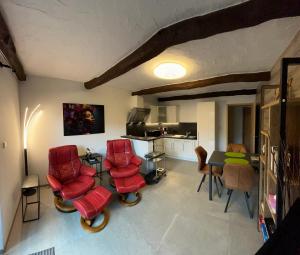 布永热尔内勒度假屋的客厅配有红色椅子和桌子