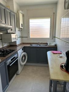 塞古德卡拉斐Playa y confort en Segur de Calafell的一个带水槽和洗衣机的小厨房