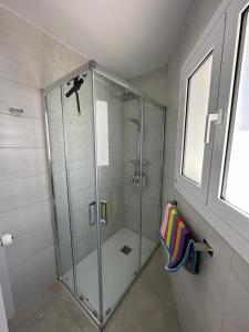 塞古德卡拉斐Playa y confort en Segur de Calafell的浴室里设有玻璃门淋浴