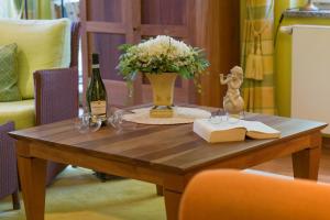 黑灵斯多夫Villa Charlotte App_13的一张桌子,上面放着花瓶和一瓶葡萄酒