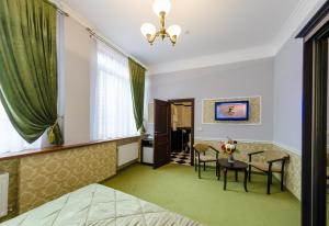 伊万诺-弗兰科夫斯克Franz Hotel&Restaurant的酒店客房带一张床、一张桌子和椅子