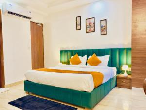 阿姆利则Hotel La Casa Amritsar Near ISBT & Golden Temple的一间卧室配有一张大床和绿色床头板