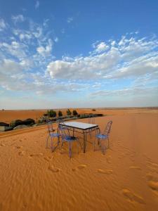 梅尔祖卡Mustapha Camp Merzouga的沙漠中的一个桌子和椅子