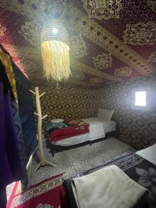 梅尔祖卡Mustapha Camp Merzouga的客房设有一张床和带吊灯的天花板