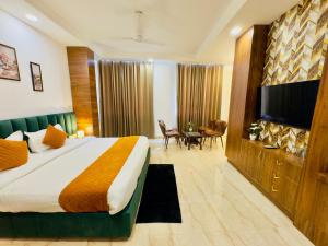 阿姆利则Hotel The Casa Hamilton, City Centre Amritsar的配有一张床和一台平面电视的酒店客房