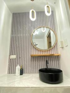 马尼拉Grace Residences Elevate Escapes的浴室设有黑色水槽和镜子