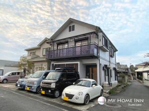 泉佐野My Home Inn Izumisano的停在房子前面的白色汽车