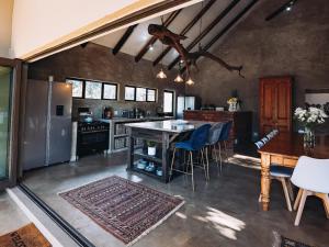 侯斯普瑞特Rhino's Rest Luxury Villa的厨房配有桌子、椅子和柜台