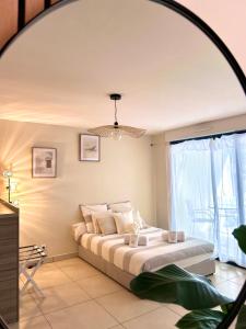蒙特卡罗Studio NEUF - PORTES DE MONACO - Confort - Wifi - Clim的一间卧室设有一张床和一个大窗户