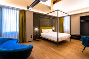 博洛尼亚旅游酒店的一间卧室配有天蓬床和蓝色的沙发