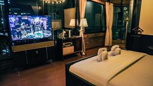 邦帕利勒塔纳酒店的一间卧室配有电视和一张饲养着两个动物的床