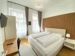 维也纳Vienna Stay Apartments or Rooms 1050的卧室配有一张白色大床和一张书桌
