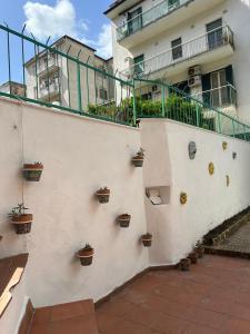 福尔米亚Casa vacanza Paradiso B&B的白色的建筑,旁边是盆栽植物