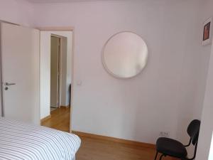 里斯本Sunny Two Bedroom Apartment的卧室配有椅子和墙上的镜子