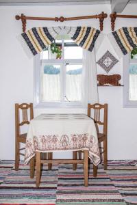 苏恰维塔Casa Felicia的窗户间里的一张桌子和两把椅子
