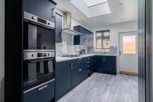 贝肯翰姆Exquisite Double Room的一间设有蓝色橱柜和天窗的大厨房