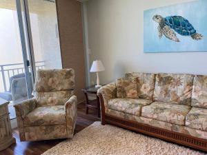 新士麦那海滩Pelican Condominium的客厅配有沙发和椅子