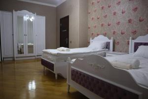 巴库Baku Red Villa的一间卧室设有两张床和鲜花墙