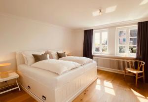 凯图姆Reethus Keitum的白色的卧室设有白色的床和窗户。