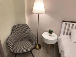 台中市舒悦文旅 台中逢甲店 的一间卧室配有椅子和床头灯