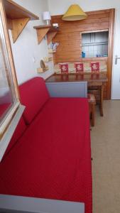 蒂涅BORSAT 4的客厅配有红色的沙发和桌子