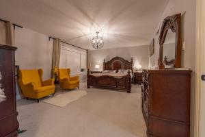 渥太华Huge House的一间卧室配有一张床和两张黄色椅子
