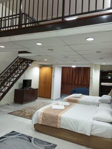 吉隆坡梅楼公寓酒店的一间带两张床和楼梯的大卧室