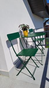 GiarmataHomestay near motorway的绿桌和椅子,盆栽