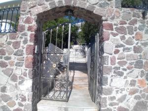 AegenitissaΑίγινα εξοχική κατοικία的石头建筑的入口,有铁门