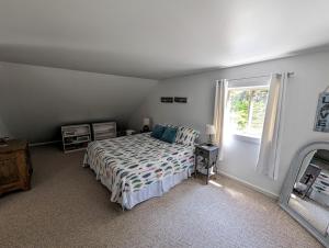 Prospect HarborSunset Cove Cottage private beach的一间卧室设有一张床和一个窗口