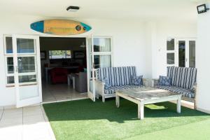 爱德华港Villa 43, The Estuary Country Estate, Port Edward, KZN South Coast的一个带两把椅子和一张桌子的庭院和冲浪板