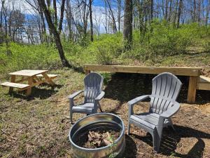 洛根Black Oak Campsite at Hocking Vacations Campsites - Tent not Included的两张椅子、一张桌子和一张野餐桌