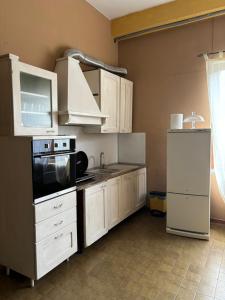 加尔法尼亚纳新堡Ostello Bellavita的厨房配有白色橱柜和炉灶烤箱。