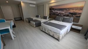 安塔利亚Antalya Dream Hotel的酒店客房带两张床和一张桌子以及椅子。