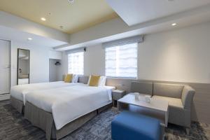 东京水道桥托克宇寄宿酒店的酒店客房,设有两张床和一张沙发
