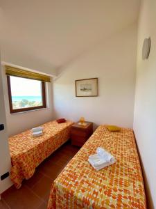 雷阿尔蒙特La Terrazza di Nonna Maria的客房设有两张床和窗户。