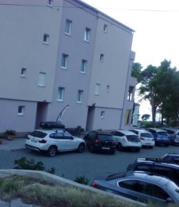 马卡尔斯卡SARITA Apartments 1的停在大楼前停车场的一群汽车