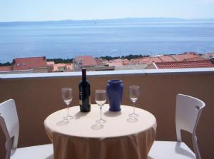 马卡尔斯卡SARITA Apartments 1的一张桌子,上面放着一瓶葡萄酒和两杯酒