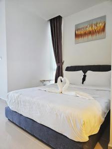 哥打京那巴鲁#8 Summer Seaview Studio Apartment at Kota Kinabalu City Centre的一间卧室配有一张带两个天鹅的床