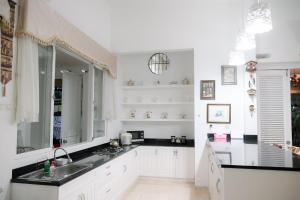 茂物Kirana Guest House Bogor的白色的厨房配有水槽和镜子