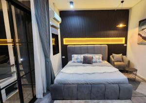 Ban Khlong SamrongLS 2 Lasalle House,bts,Suvarnabhumi ,mega bangna的一间卧室配有一张大床和一把椅子