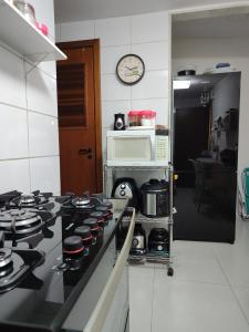 维多利亚Quarto e banheiro privativos com garagem fechada em apartamento aconchegante em Jardim da Penha的厨房配有炉灶、烤箱和微波炉