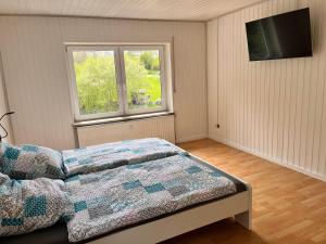 Herdwangen-SchönachAlte Mühle - Ferienwohnung Tamara的一间卧室设有一张床和一个窗口