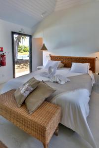 MataieaSublime Tahiti Beach Retreat的一间卧室设有两张床和柳条凳