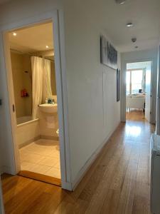 都柏林The Fitz Apartment的走廊设有1间带浴缸和卫生间的浴室