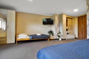 Růžová鲁扎克旅馆的一间卧室配有蓝色的床和一台平面电视