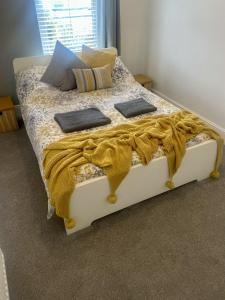 卡迪夫Cosy Vibes Central Cardiff House的一张带黄色毯子和枕头的床