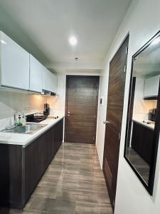 马尼拉Heart of Makati, Fully furnished condo, cbd central location的一个带水槽和木门的厨房